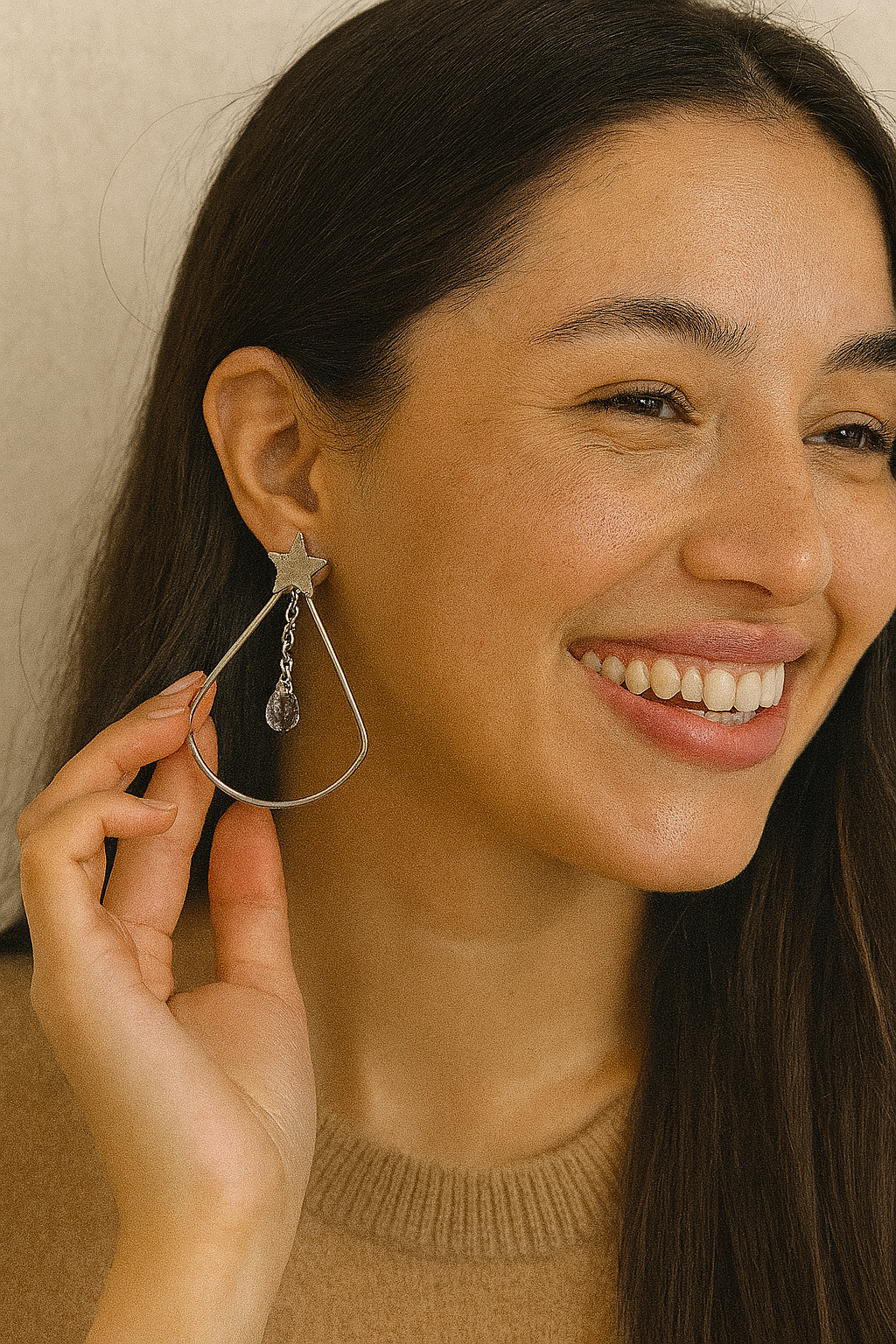 Brinco de aço inox hipoalergênico com gota vazada, uma estrela e uma zircônia transparente.