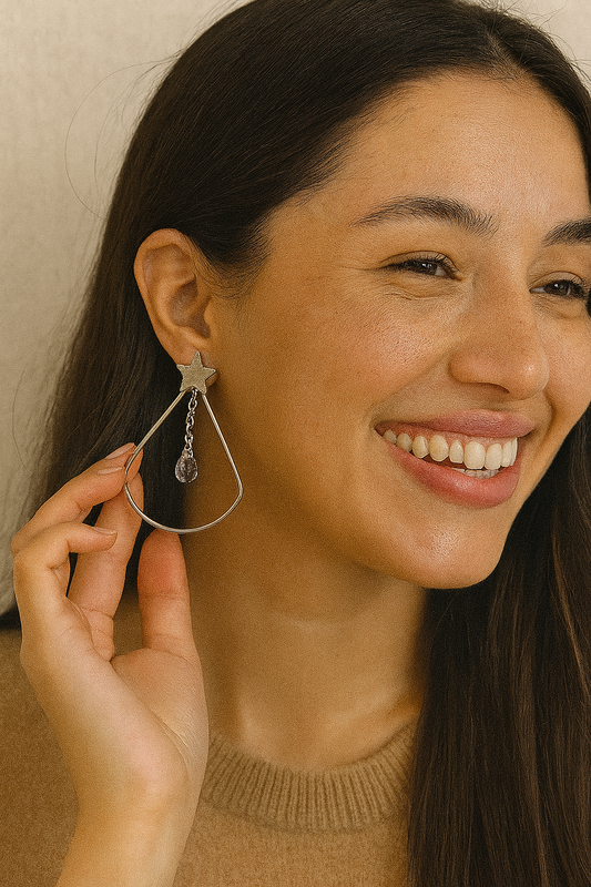 Brinco de aço inox hipoalergênico com gota vazada, uma estrela e uma zircônia transparente.